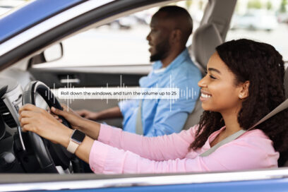 Smiling beautiful African American woman driving modern luxury car, happy young man sitting on the front passenger seat, looking on the road
