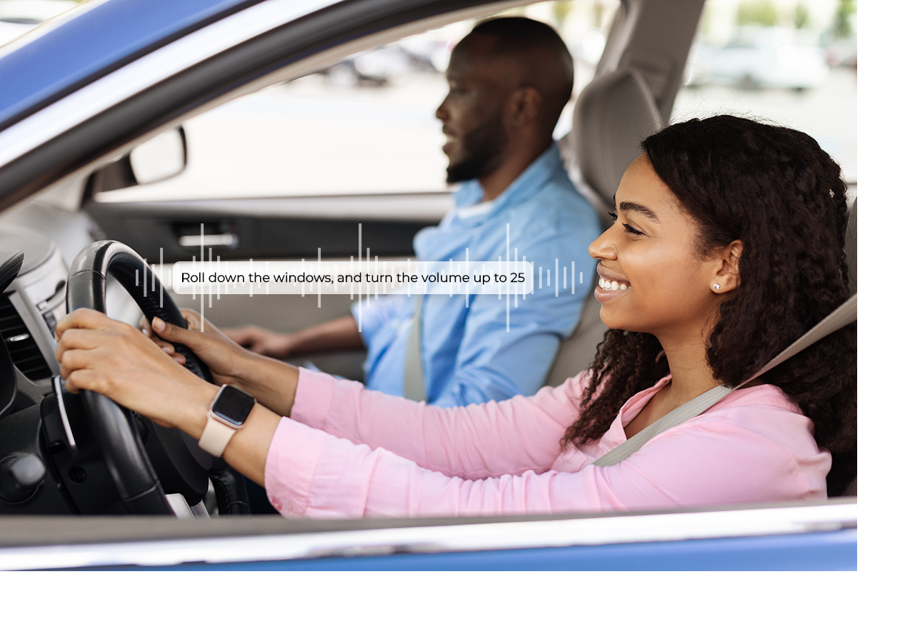 Smiling beautiful African American woman driving modern luxury car, happy young man sitting on the front passenger seat, looking on the road
