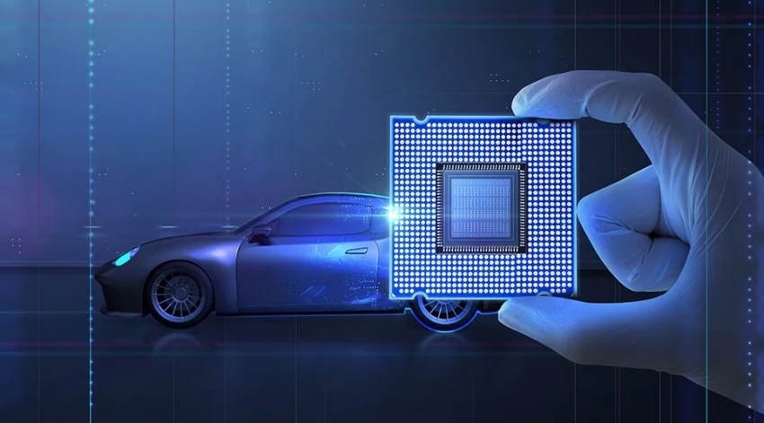 An illustration of a semiconductor held by a machine hand and a image of a vehicle in the background
