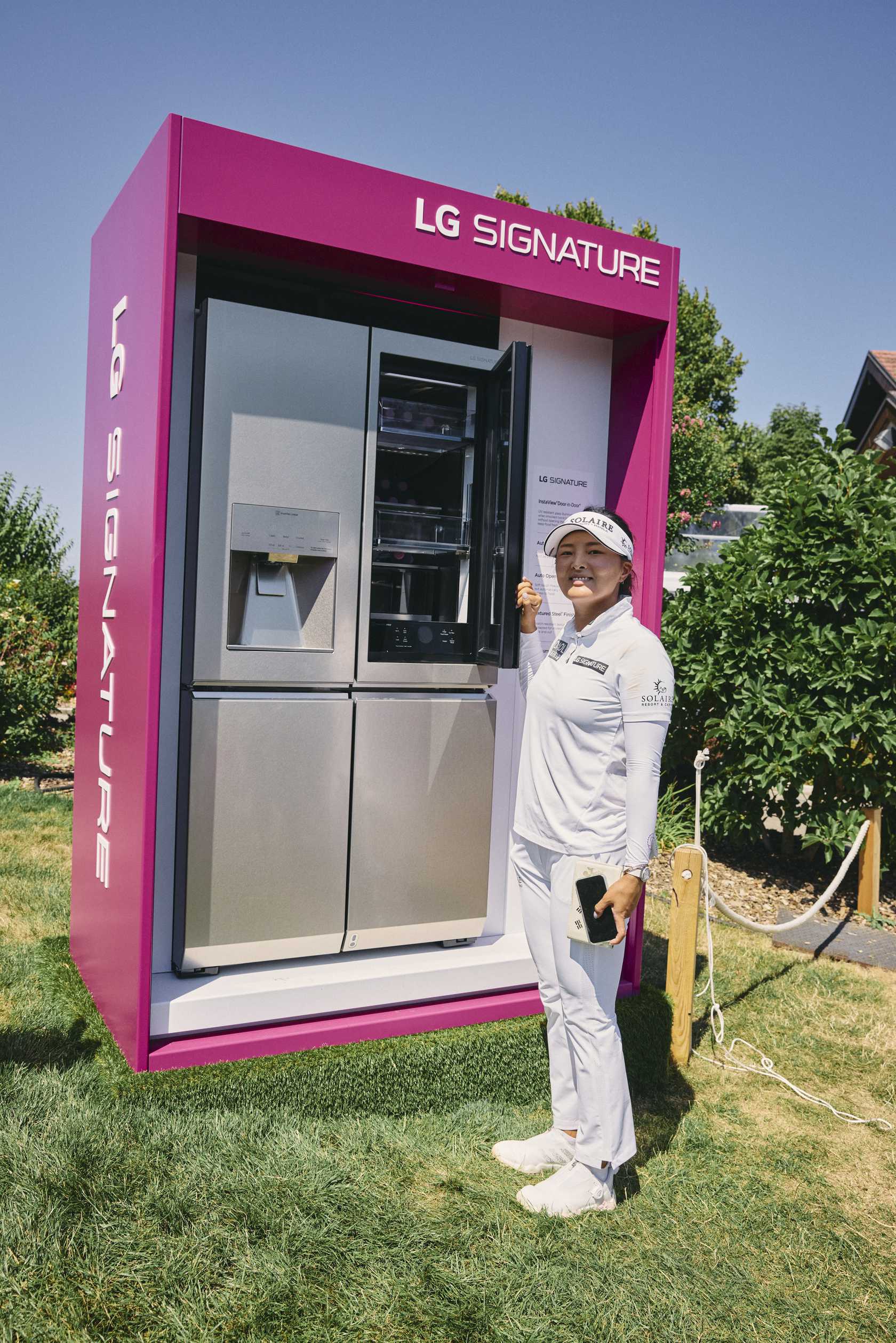 Golfer Ko Jin-young posing in front of the LG SIGNATURE InstaView Door-in-Door refrigerator displayed at the Amundi Evian Championship