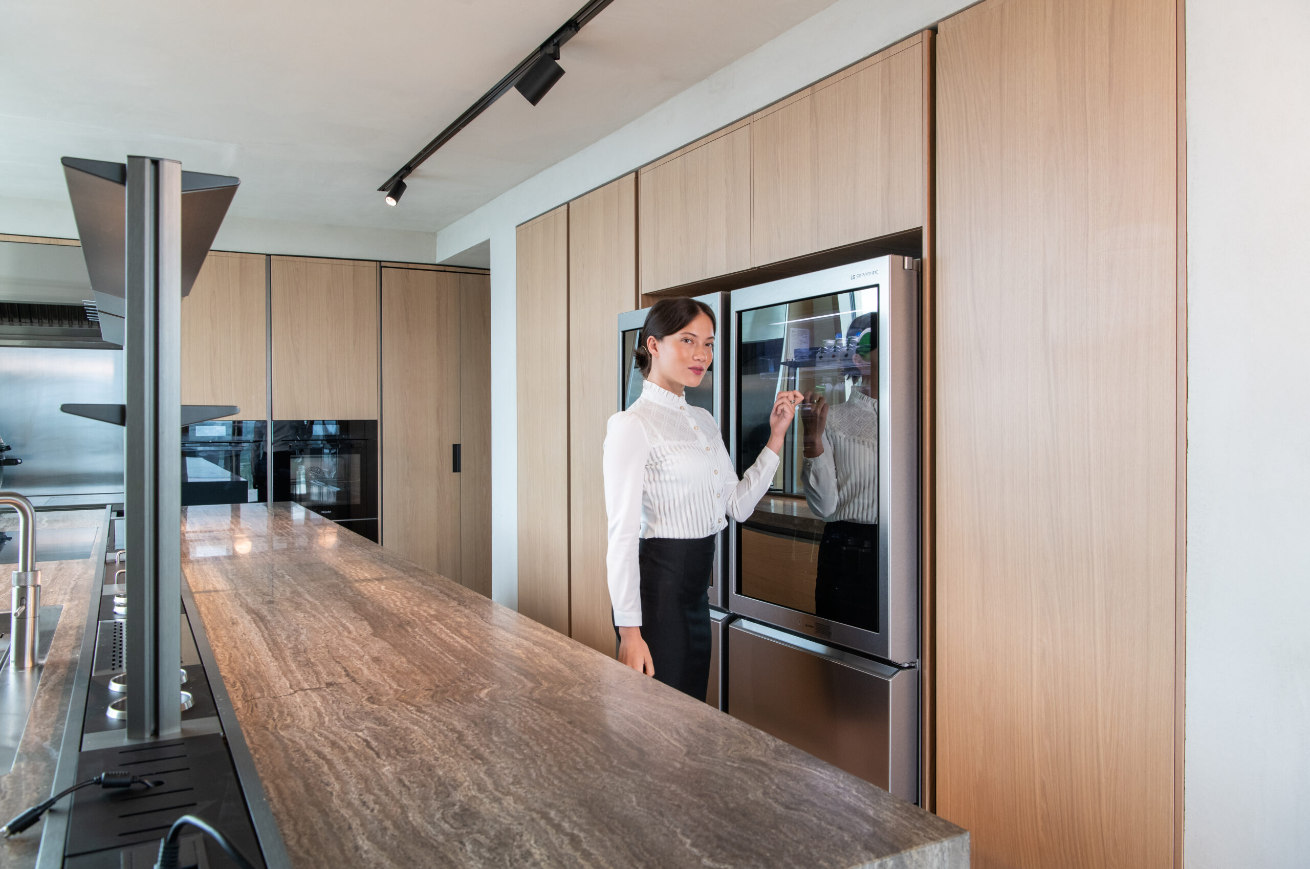 A female knocking on the door of LG SIGNATURE refrigerator to show its special feature at Molteni&C flagship store in Amsterdam.