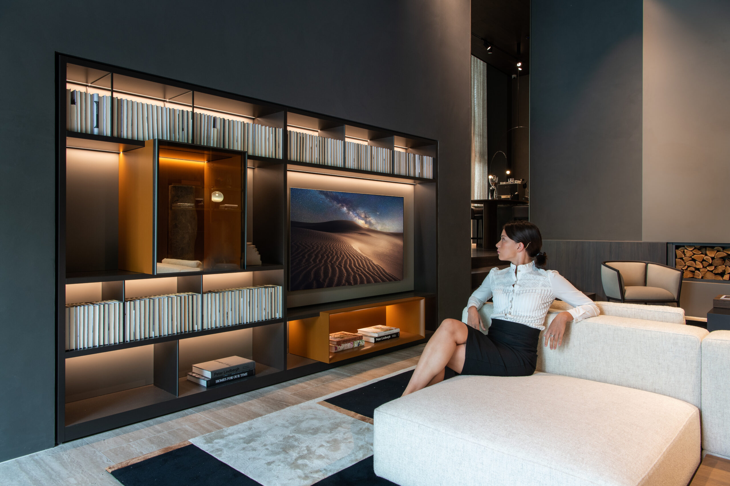 A female sitting on a couch facing LG TV displayed at Molteni&C flagship store in Amsterdam.