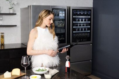 Olivia Palermo is pouring a glass of wine in front of the LG SIGNATURE InstaView™ Door-in-Door® Refrigerator.