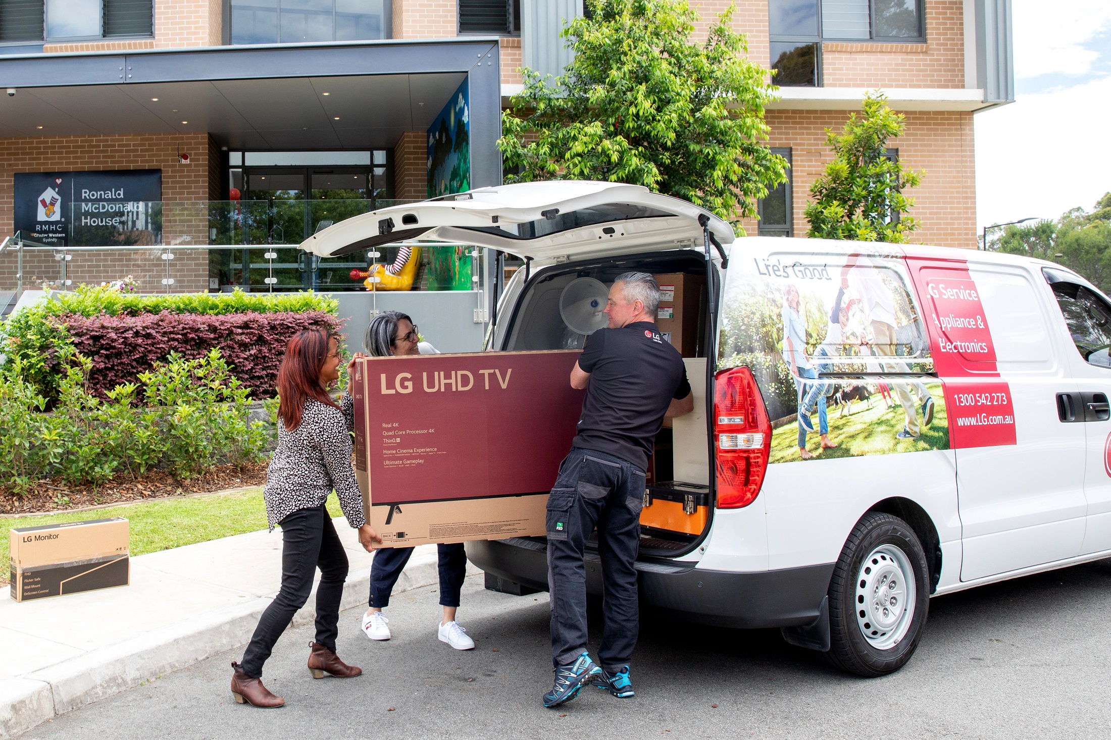 RMHC staff taking donated LG UHD TV out from a van