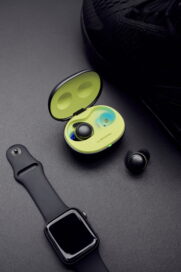 LG TONE Free fit earbuds and UVnano charging case next to a smart watch which it can integrate with to better track workouts