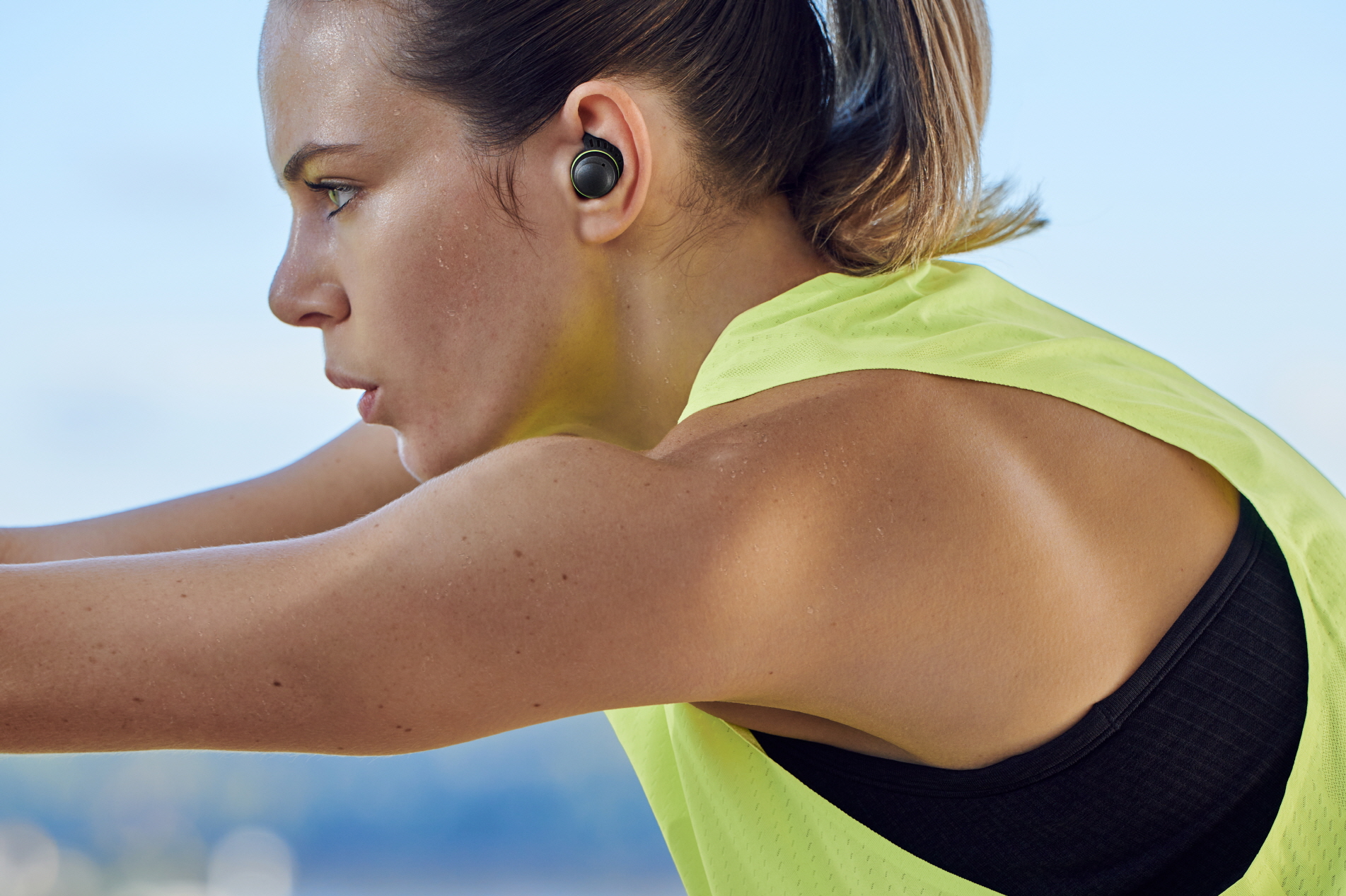 A woman working out while wearing the sweat-resistant LG TONE Free fit earbuds.
