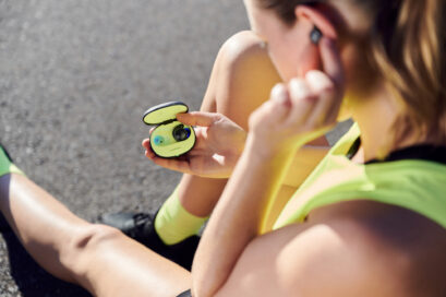 A women resting while putting her LG TONE Free fit earbuds back in its vibrant UVnano charging case