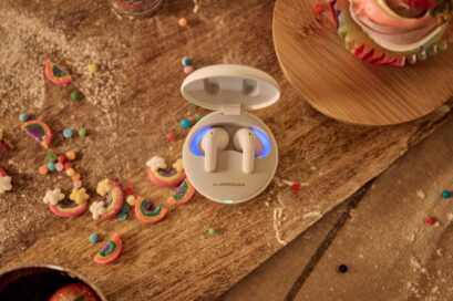 LG TONE Free in white on a table surrounded by colorful desserts