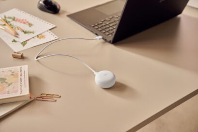 White LG TONE Free earbuds in its case plugged into a laptop