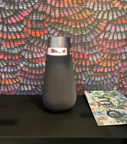 Close shot of LG XBOOM 360 speaker pictured on top of a desk at LG's booth at IFA 2022