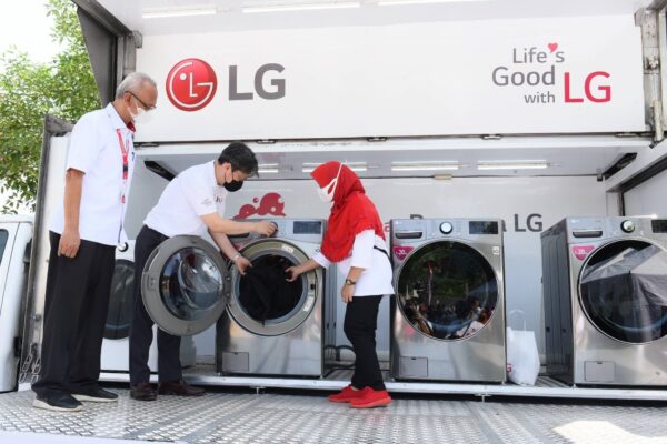 LG Staff demonstrating how to use LG washer and dryer installed on a truck