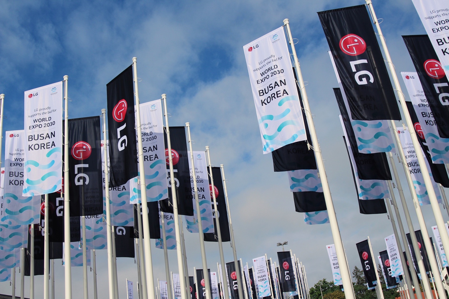 Promotional flags of LG logo and Busan's bid for World Expo 2030 flying in front of Messe Berlin during IFA 2022