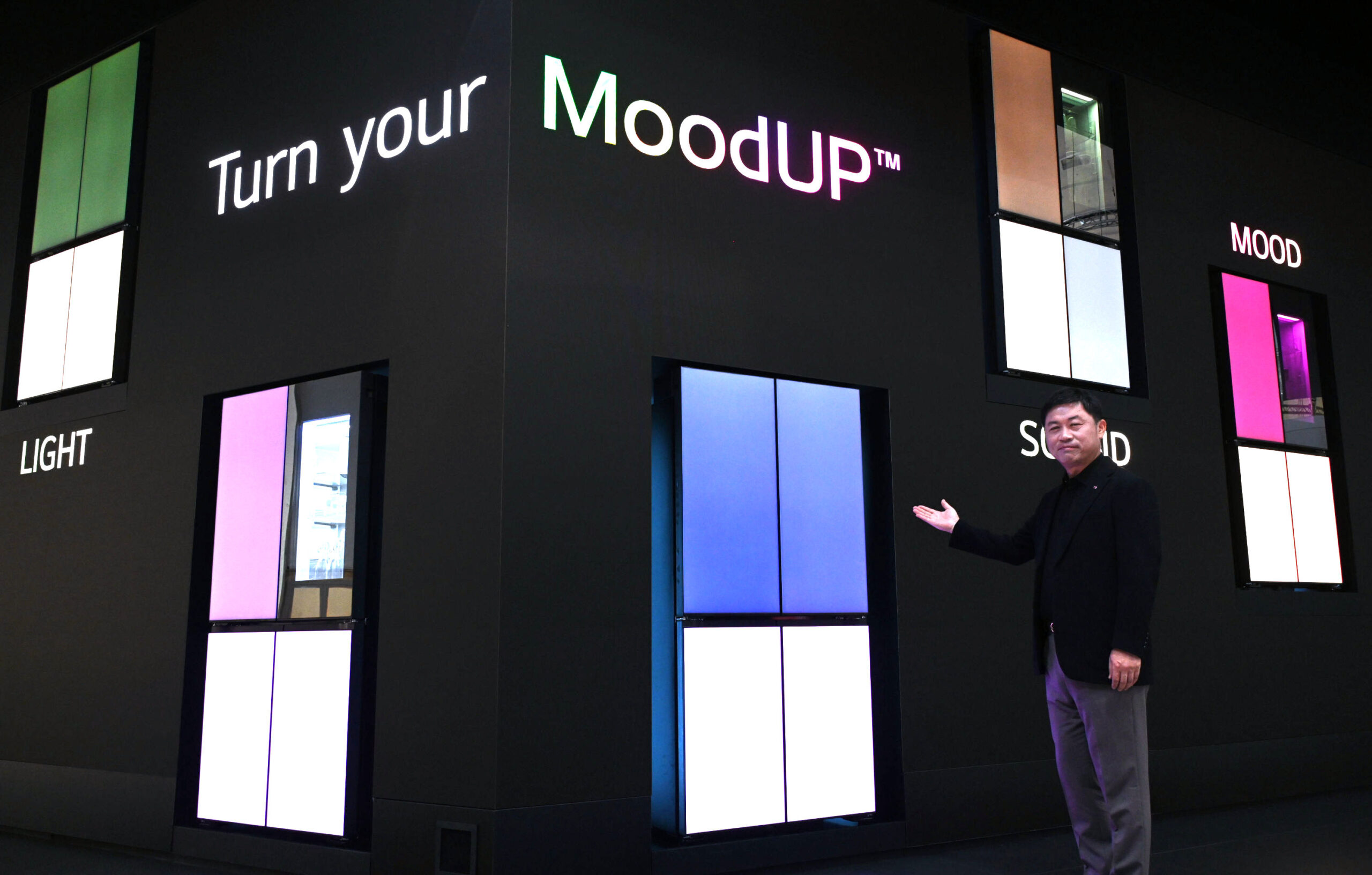 A man on the right is indicating at one of MoodUPTM refrigerators in front of the LED wall at IFA 2022