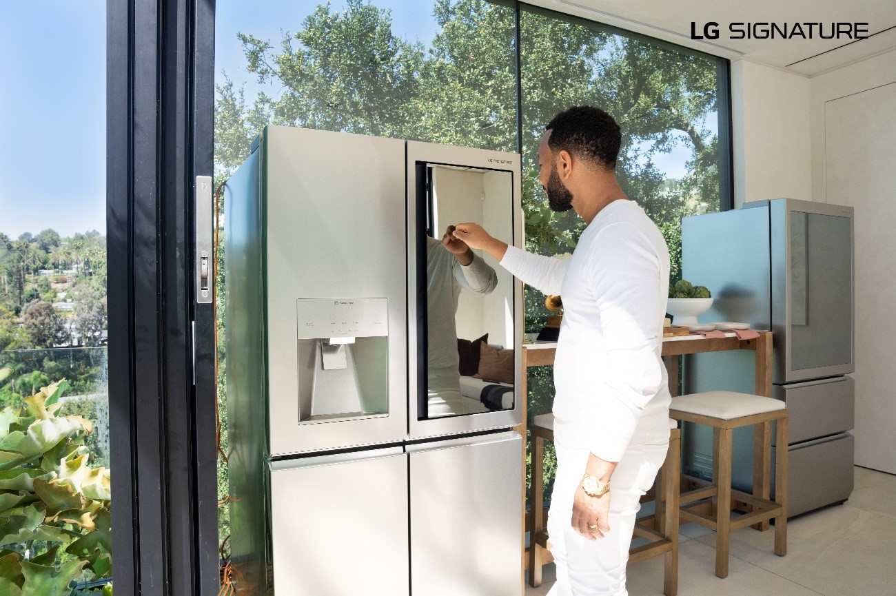 John Legend knocking on the mirrored glass panel of LG SIGNATURE InstaView Door-in-Door refrigerator