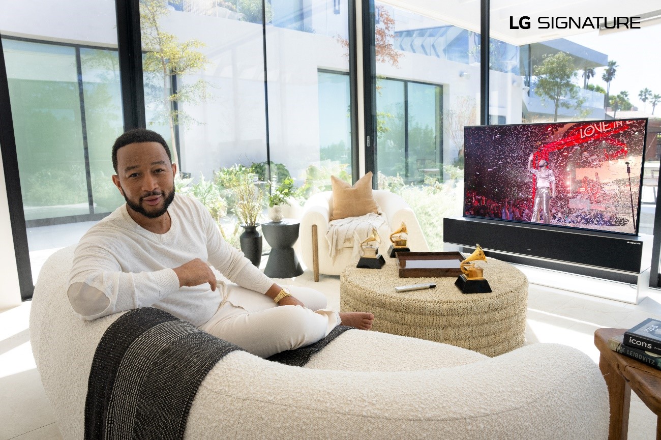 John Legend sitting in front of his LG SIGNATURE OLED R TV while talking to the camera