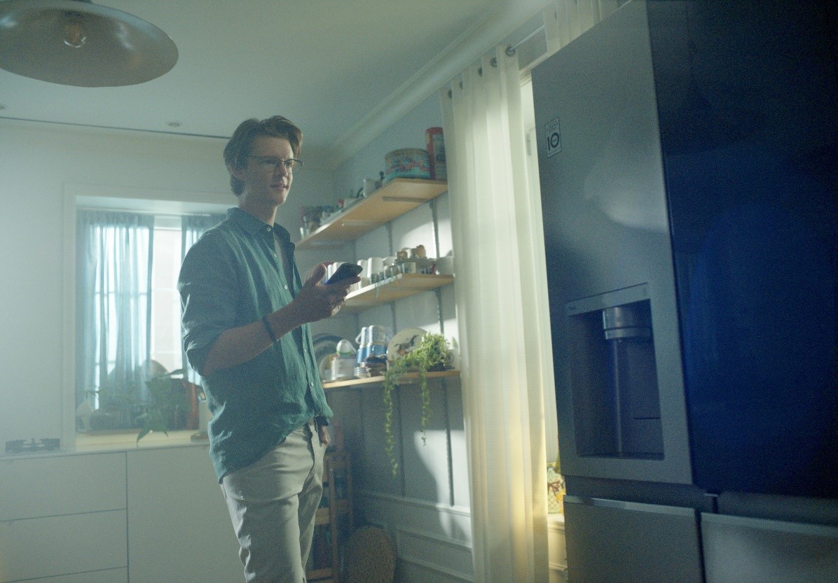 A man interacting with the LG refrigerator via smartphone