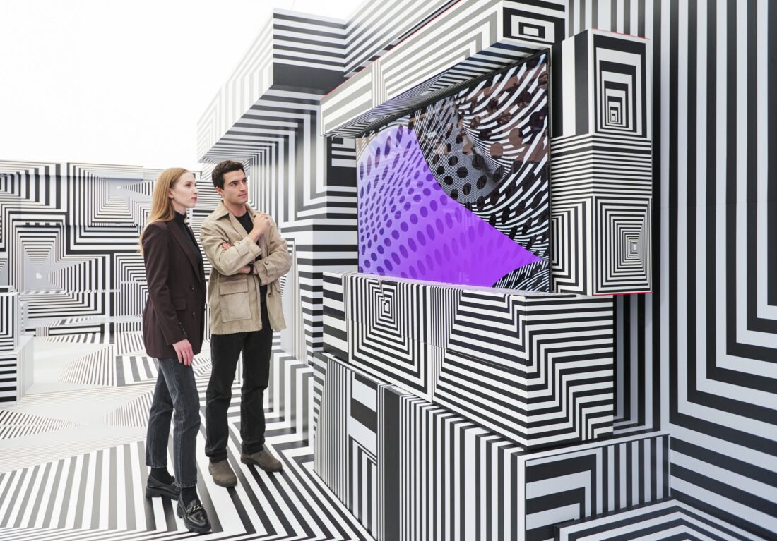 Two visitors taking a closer look at LG OLED-powered “Into the Maze” installation by the German artist, Tobias Rehberger