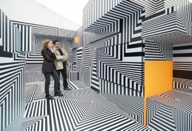 Two visitors taking a closer look at LG OLED-powered “Into the Maze” installation by the German artist, Tobias Rehberger