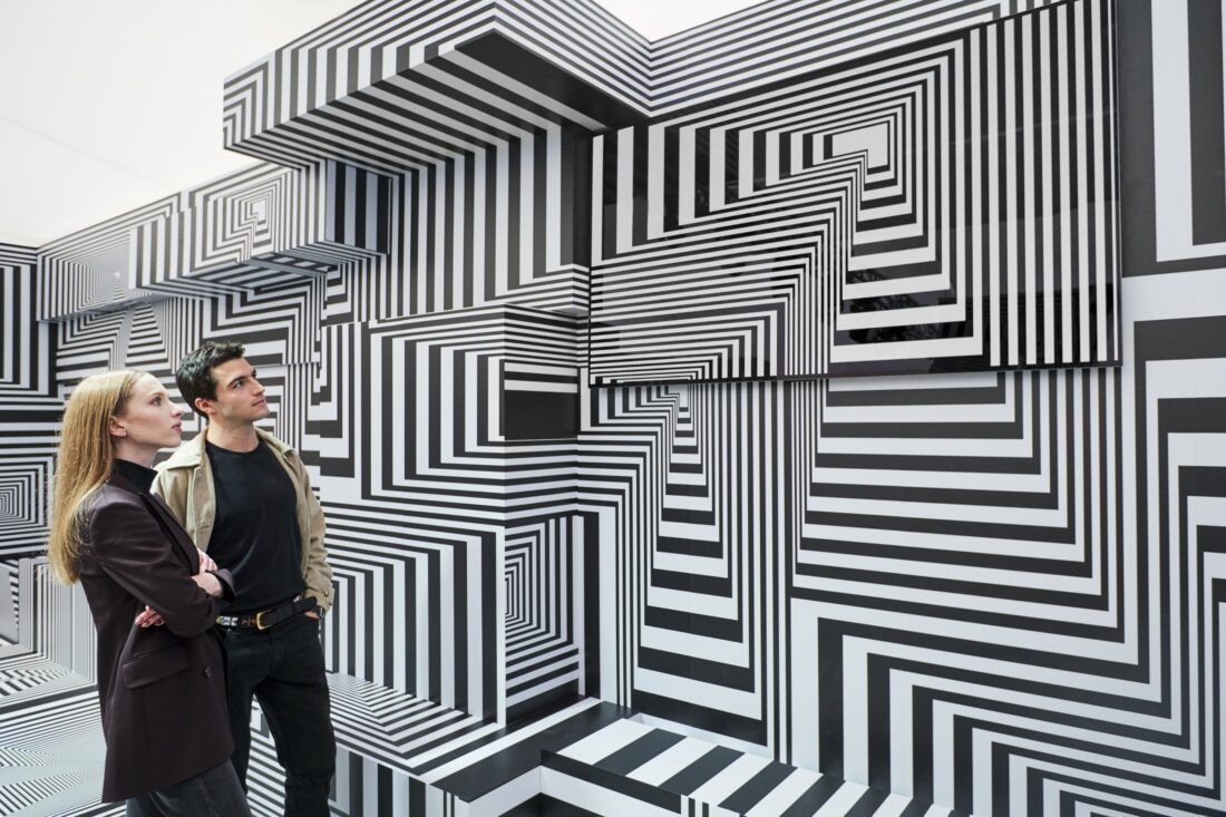 Two visitors taking a closer look at LG OLED-powered “Into the Maze” installation by the German artist, Tobias Rehberger