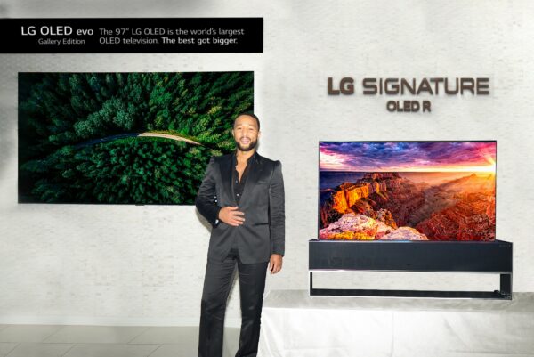 Singer John Legend posing in front of LG 97-inch G2 OLED evo TV and LG SIGNATURE OLED R TV at CEDIA Expo 2022