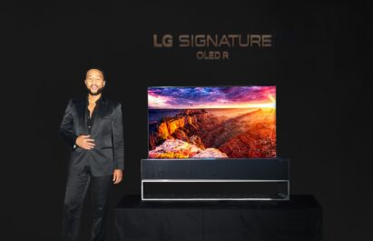 Singer John Legend posing in front of LG SIGNATURE OLED R TV in the dark at CEDIA Expo 2022