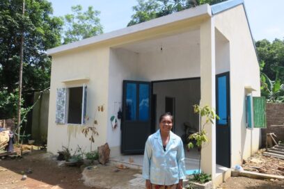Bui Thi Luc, a resident of the Ruong Denh village, posing in front of her house which was rebuilt through the Hope Village project