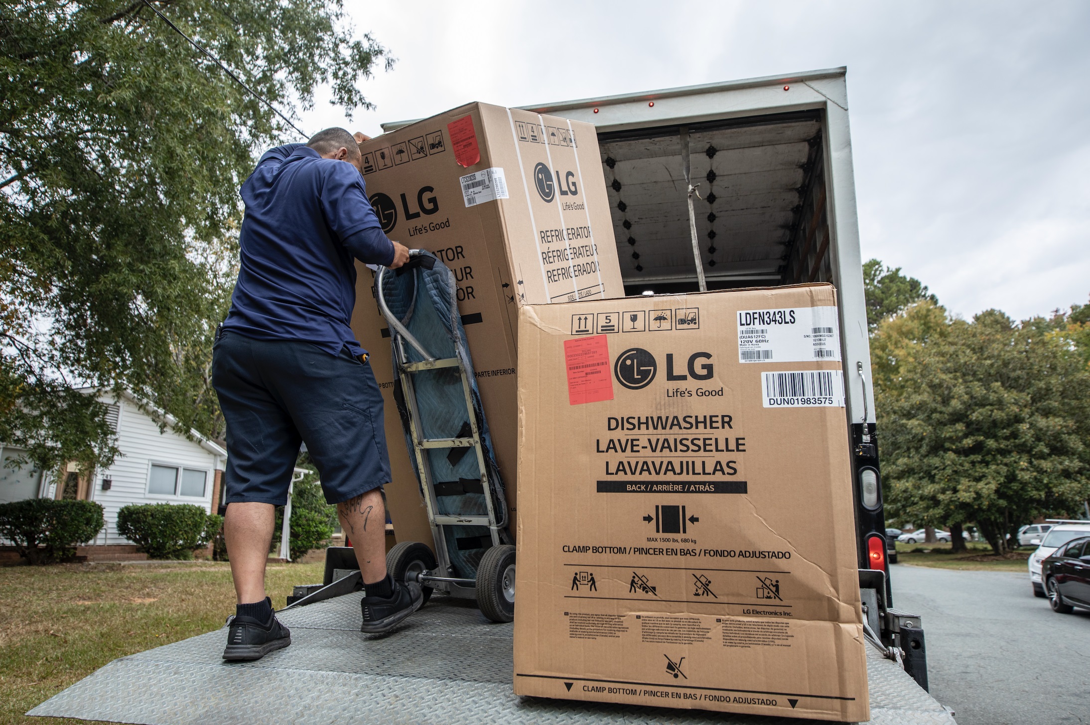 A volunteer carefully unloading the donated LG appliances from a truck