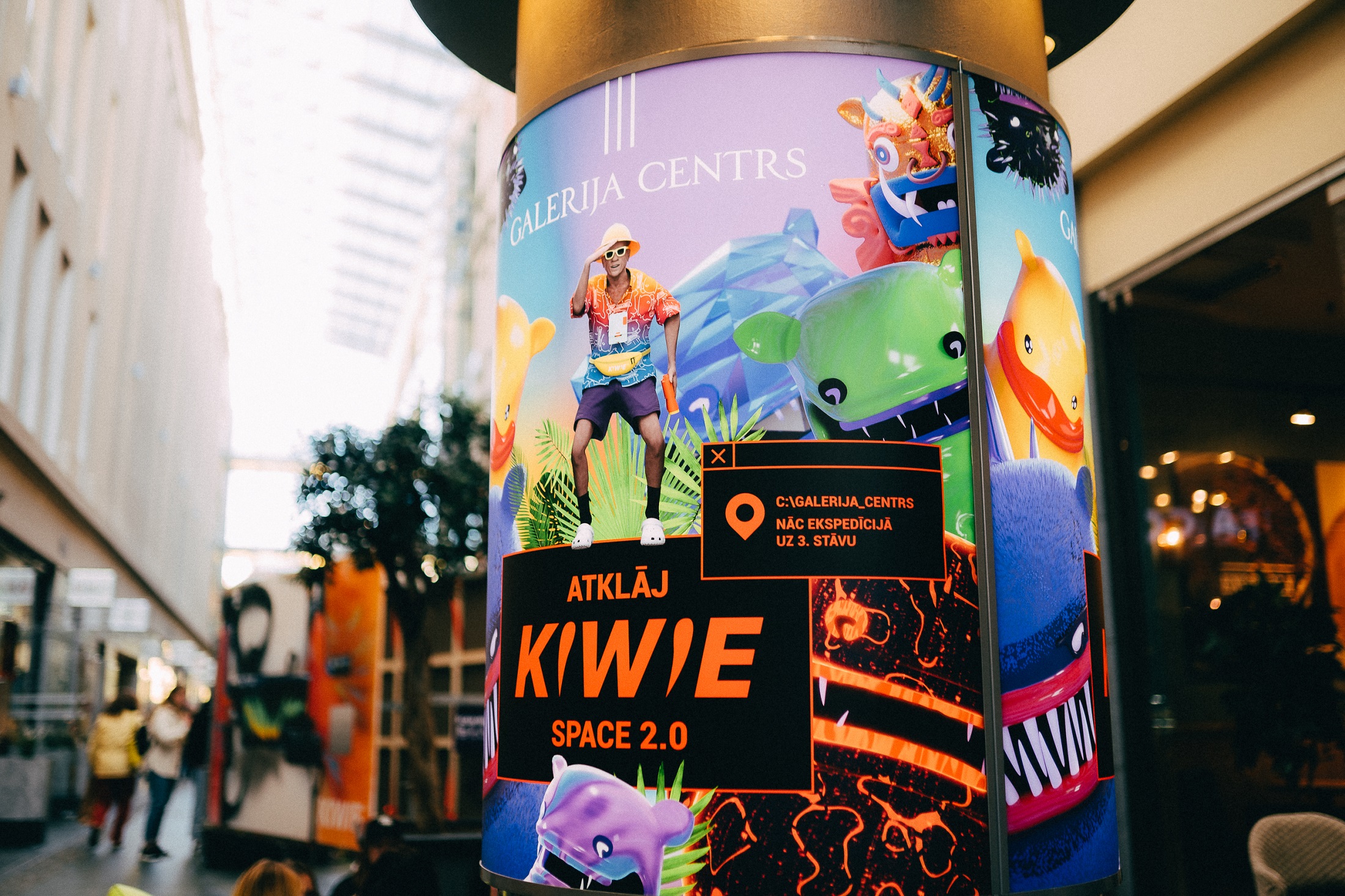 A promotional poster for KIWIE Exhibition featuring vivid colors and KIWIE monster character