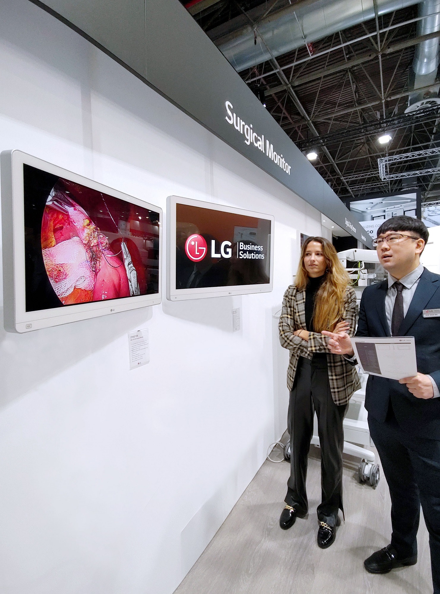 LG booth in MEDICA – A staff introduces LG medical monitors to a visitor