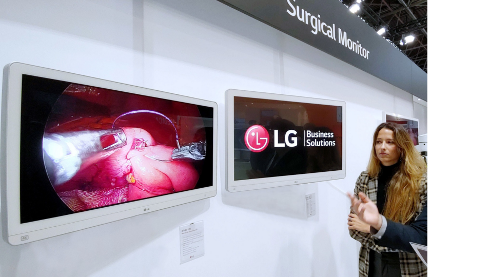 LG booth in MEDICA – A staff is introducing LG medical monitors to a visitor