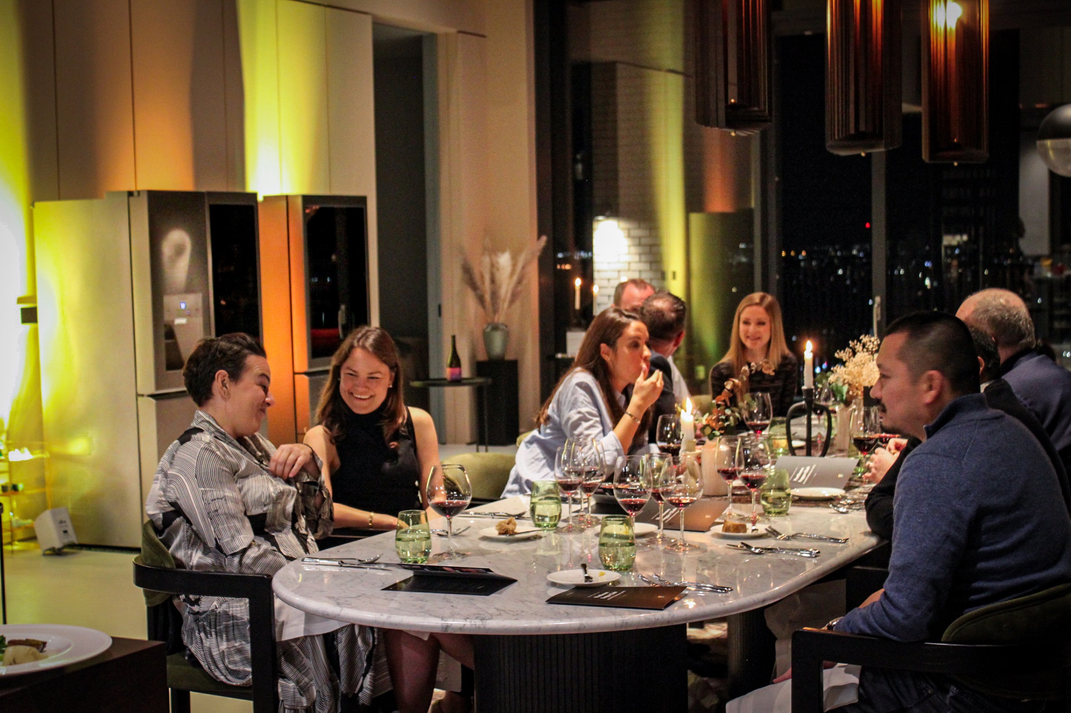 Guests of LG SIGNATURE’s wine tasting series enjoying conversation and wine around a table at London Restaurant Festival