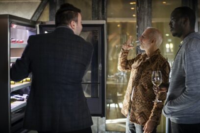 Three men examining LG SIGNATURE Wine Cellar while enjoying a glass of wine