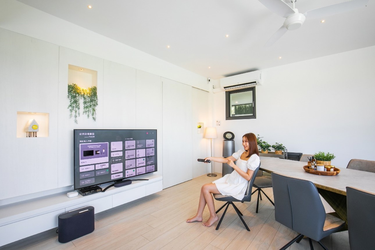Woman browsing through TV channels with the remote inside the LG ThinQ One-Bedroom Pool Villa at The Westin Yilan Resort
