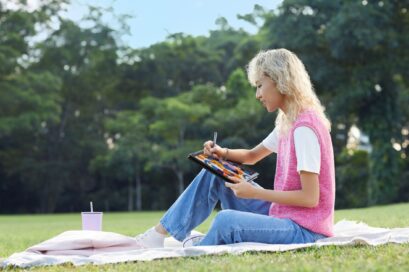 A woman using LG gram 2-in-1 having a picnic on a meadow