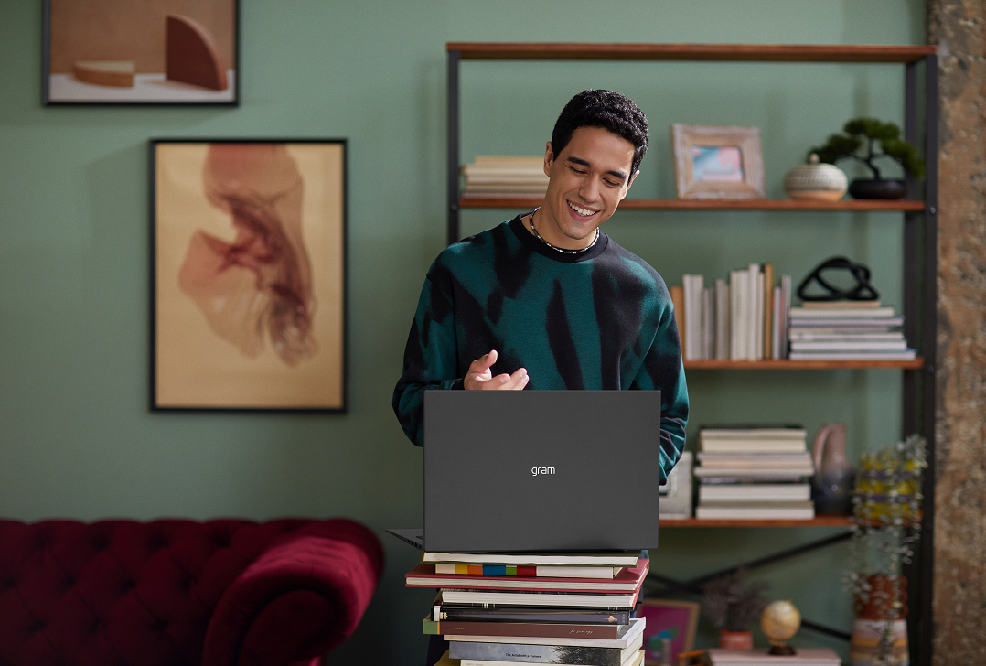 A amn using LG gram by putting the device on the stack of books