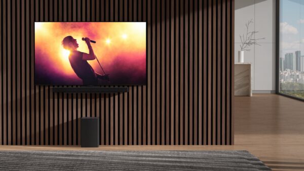 Nnew LG sSoundbar and wireless subwoofer harmonizing with an LG TV in an apartment as it displays a music concert with bright lights