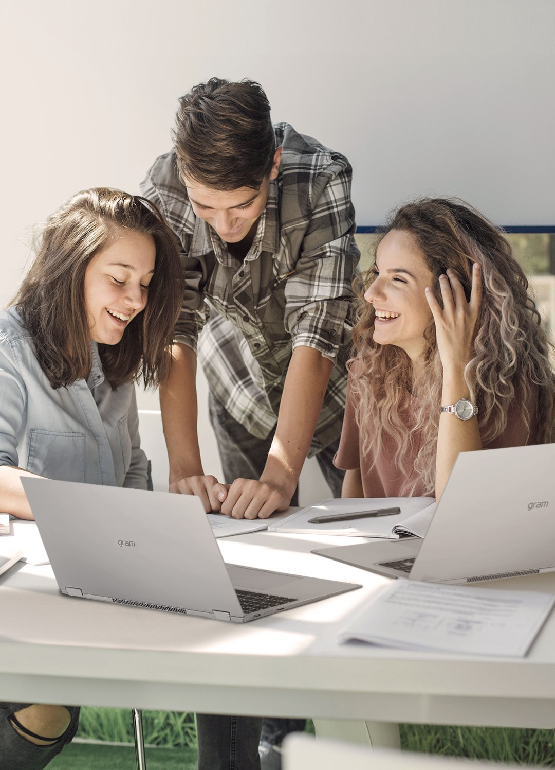 Three students working on a project using LG gram