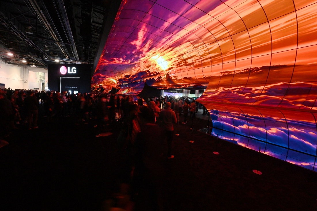 Two of LG’s newly unveiled LG Transparent OLED model displayed in a dark room with bright lights, one transparent and the other displaying content