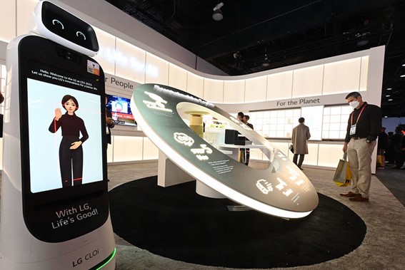 A side view of the LG Better Life for All zone at CES 2023 and LG CLOi Bot displaying Reah Keem