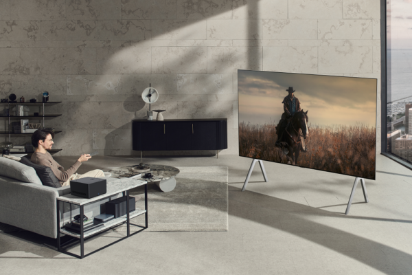 A man watching a TV series on the new LG OLED M3 while sitting on his living room sofa