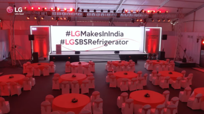 The big screen on the main stage displaying “#LG Makes in India” and “#LG SBS Refrigerator” at an offline event commemorating the company’s upgraded manufacturing facility in India.