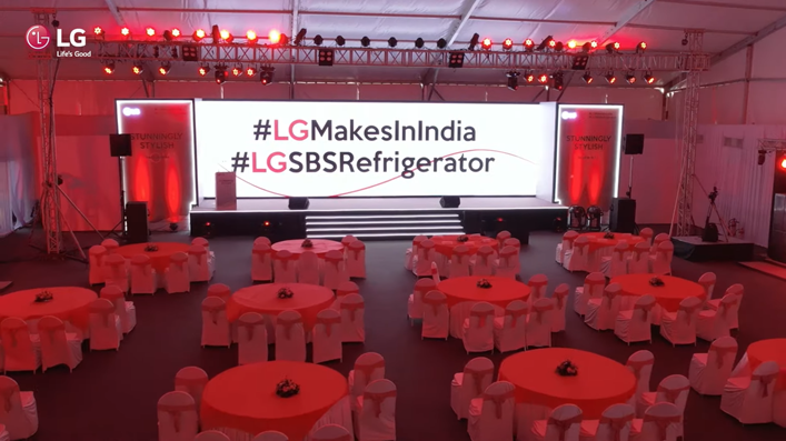 The big screen on the main stage displaying “#LG Makes in India” and “#LG SBS Refrigerator” at an offline event commemorating the company’s upgraded manufacturing facility in India. 