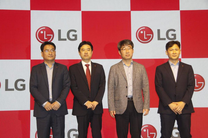 LG executives Ji Hyoung-sub, Jeon Hong-ju, Lee Hyun-uk and Kim Jae-il posing for a group photo in front of LG logos. 