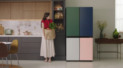 A woman holding a bag of groceries is standing next to LG MoodUP InstaView™ refrigerator