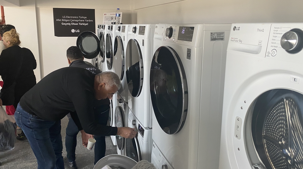 A man trying to use LG washer and dryer installed at free laundry facility that LG built to support victims of disastrous earthquake in Türkiye