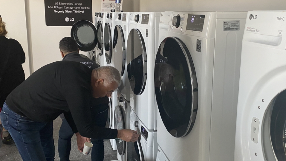 A man trying to use LG washer and dryer installed at free laundry facility that LG built to support victims of disastrous earthquake in Türkiye