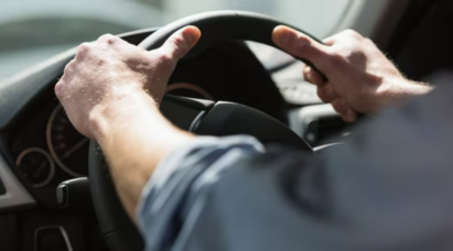 A driver tightly holding on to the steering wheel