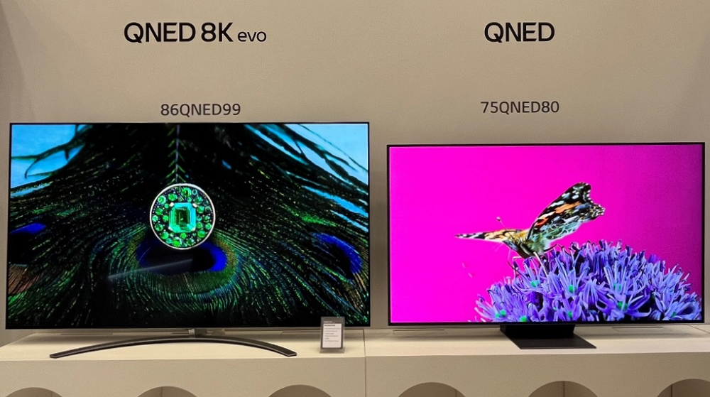 LG’s 2023 QNED 8K evo TV and QNED TV displaying the colorful images of a peacock’s tail and a butterfly at the 2023 TV showcase.
