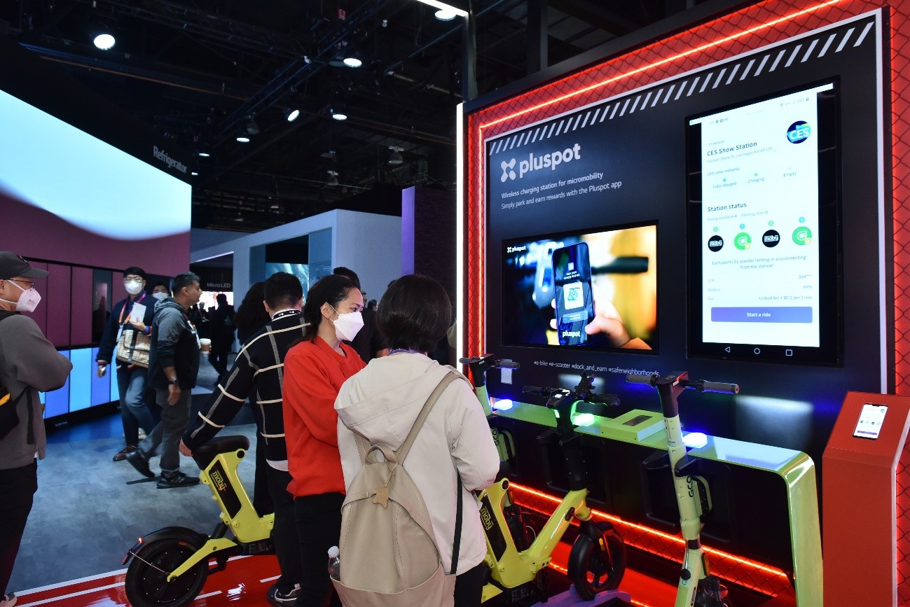 A corner of LG's booth with pluspot's products during CES 2023 where a staff is explaining features of the product to a visitor