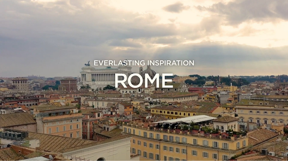 A bird's eye-view of Rome with a phrase "EVERLASTING INSPIRATION ROME" overlapping